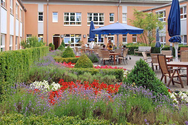 Außenbereich mit einer Gartenanlage mit vielen Blumen und Sitzgelegenheiten