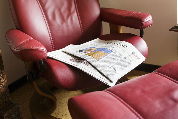 Roter Sessel mit Hocker und einer Zeitung
