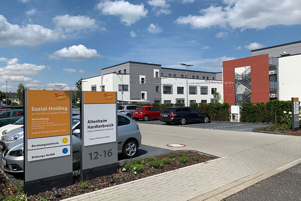Frontansicht des Altenheimes Hardterbroich mit Parkplatz und Schildern des Altenheimes
