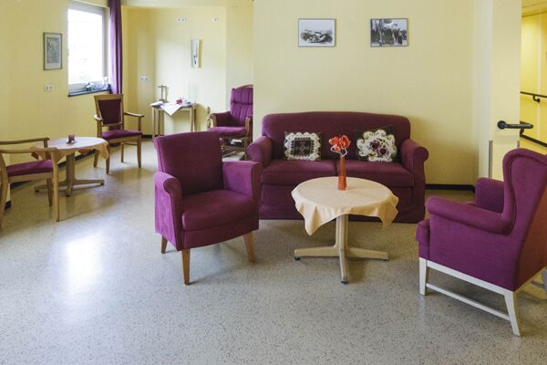 Gemeinschaftsraum im Altenheim Am Pixbusch 1, mit lila Sesseln und kleinen Tischen