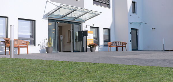 Haupteingang des städtischen Altenheims Hardterbroich mit Wiese und Bänken zum Außenaufenthalt
