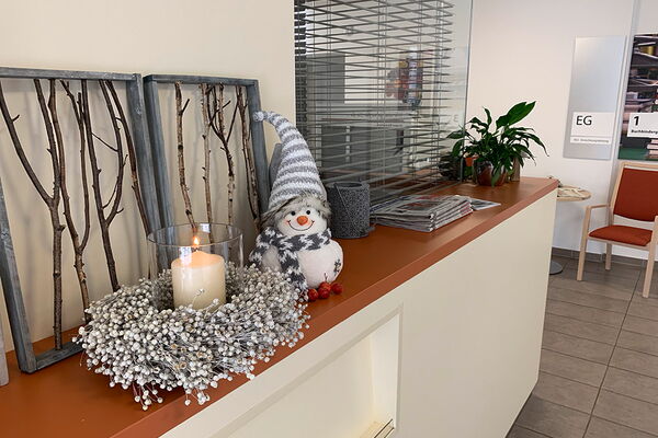 Weihnachtliche Dekoration im Altenheim Kamillus, Sideboard mit Schneemann und Kranz
